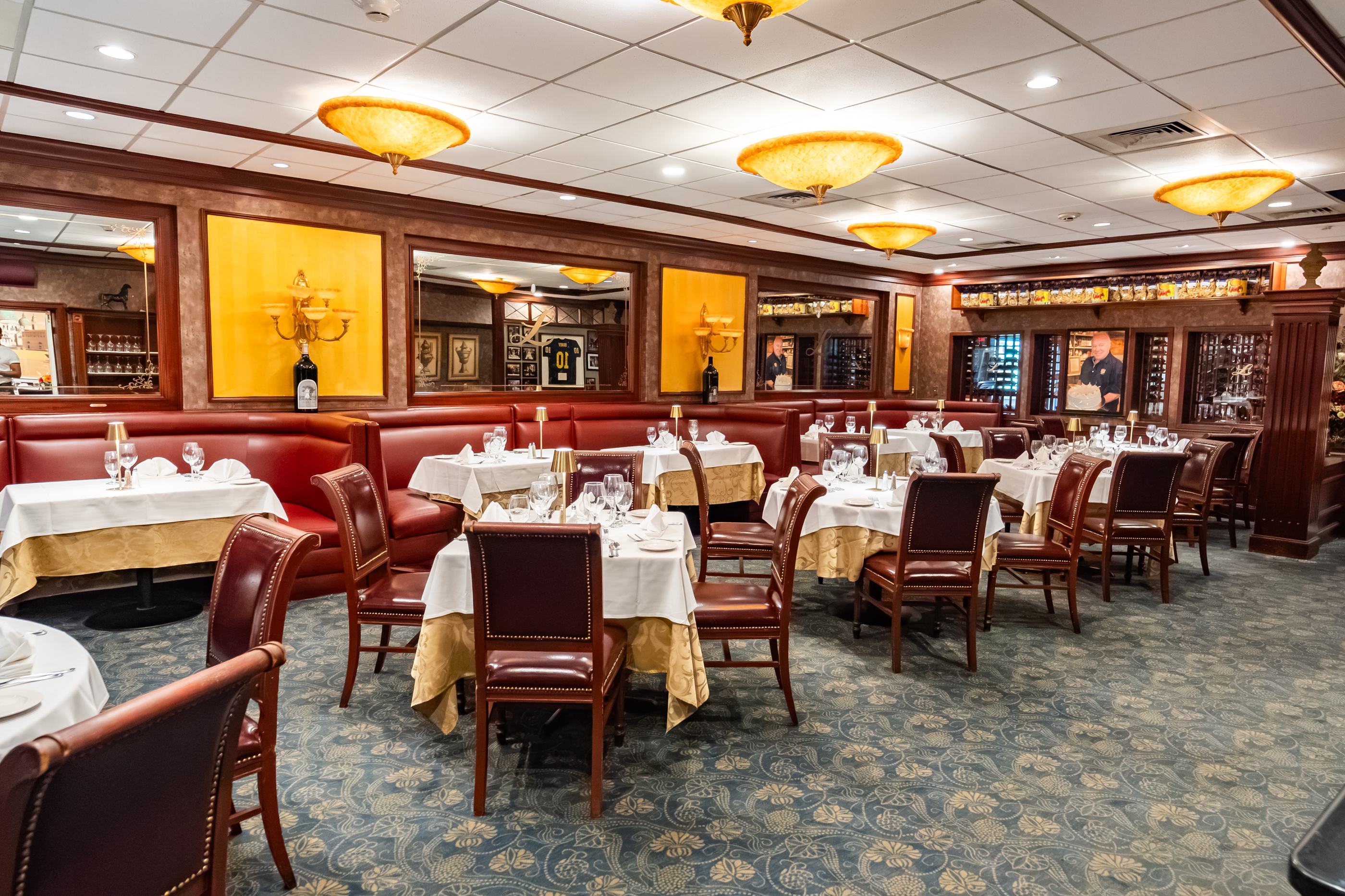 Red leather banquettes and white-linen tables in a dining room at Luciano’s
