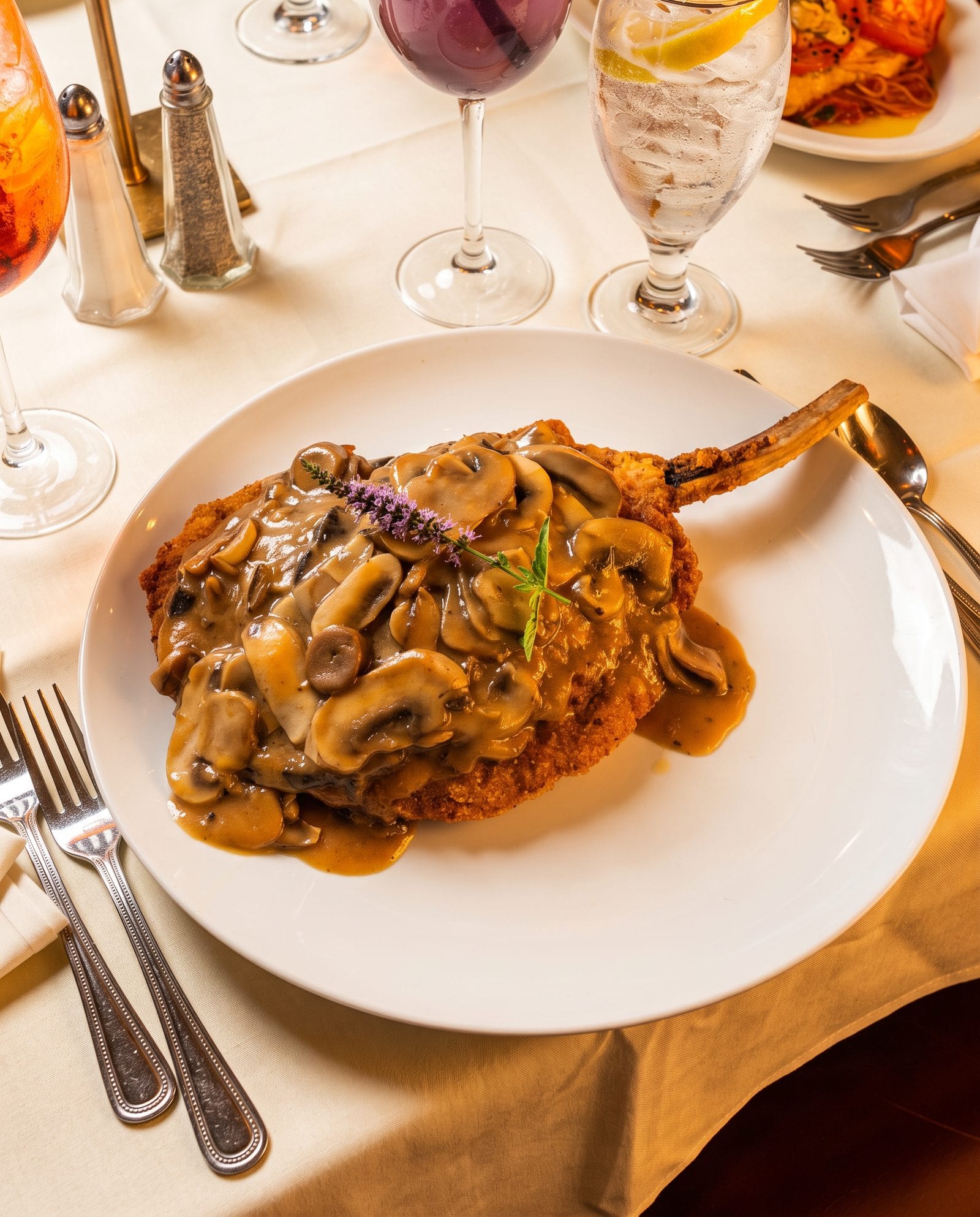 A bone-in breaded cutlet finished with mushrooms in cream sauce at Luciano’s