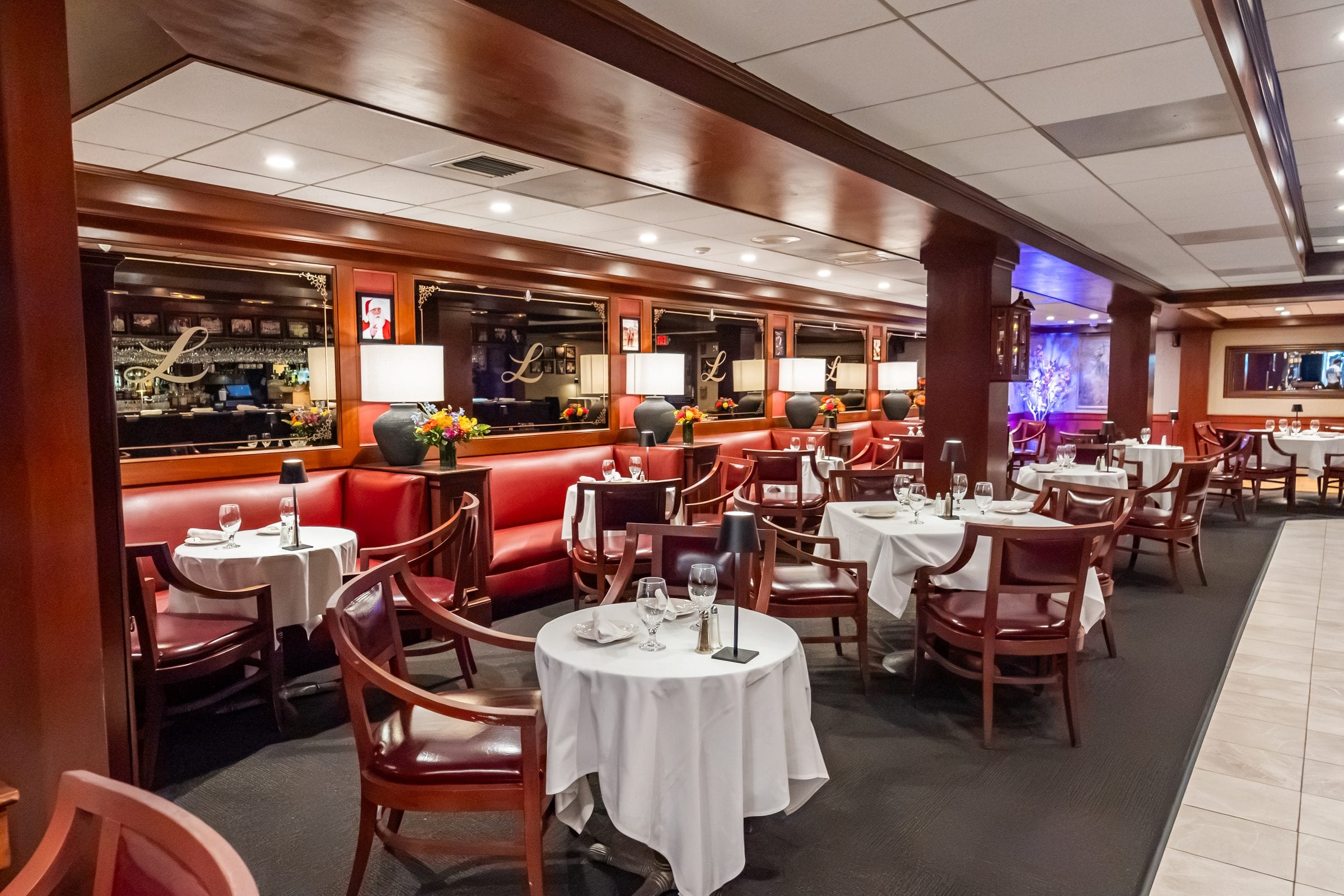 Red banquettes and white-clothed tables in the lounge at Luciano’s