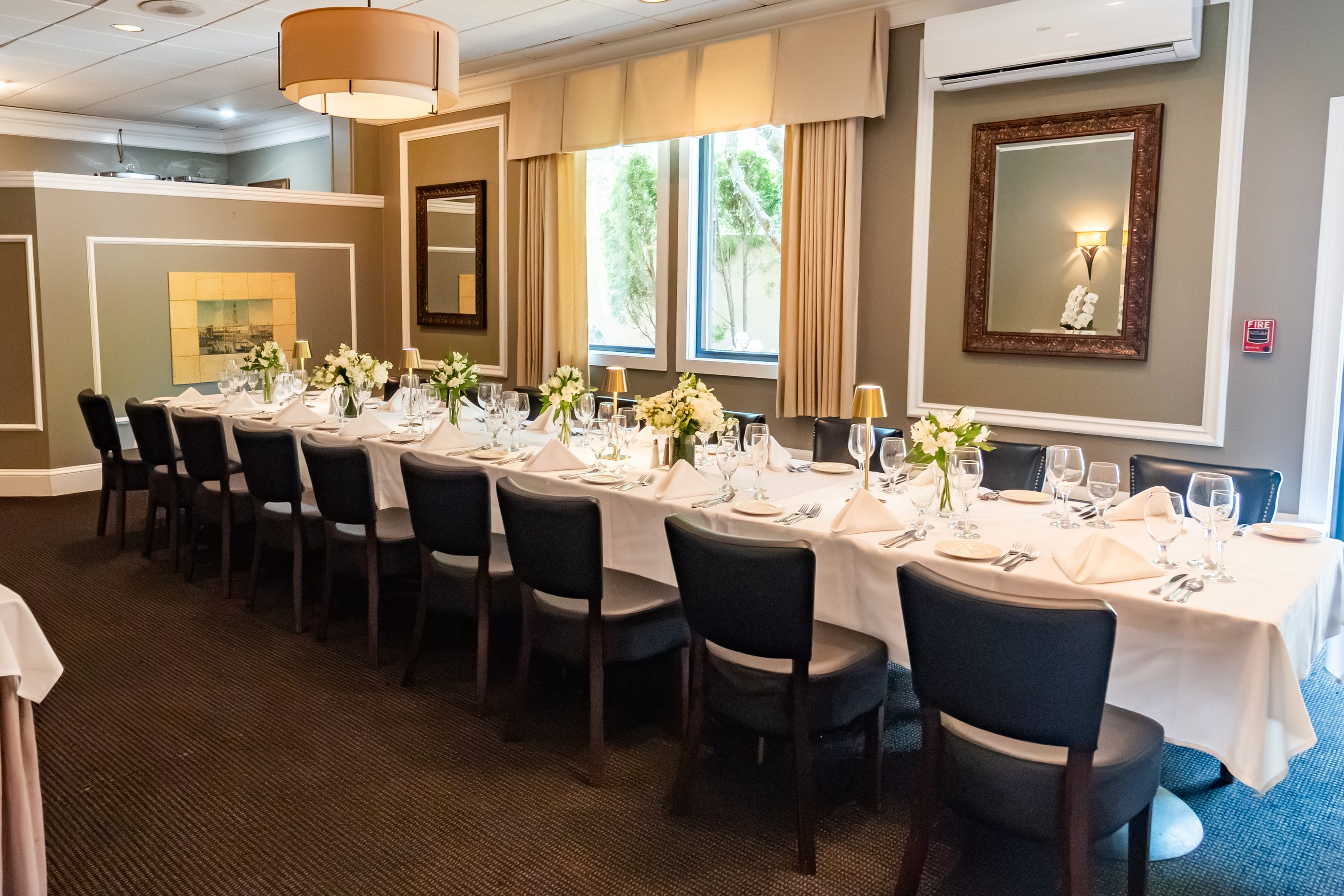 A private function room at Luciano’s set for a party, with garden-window light