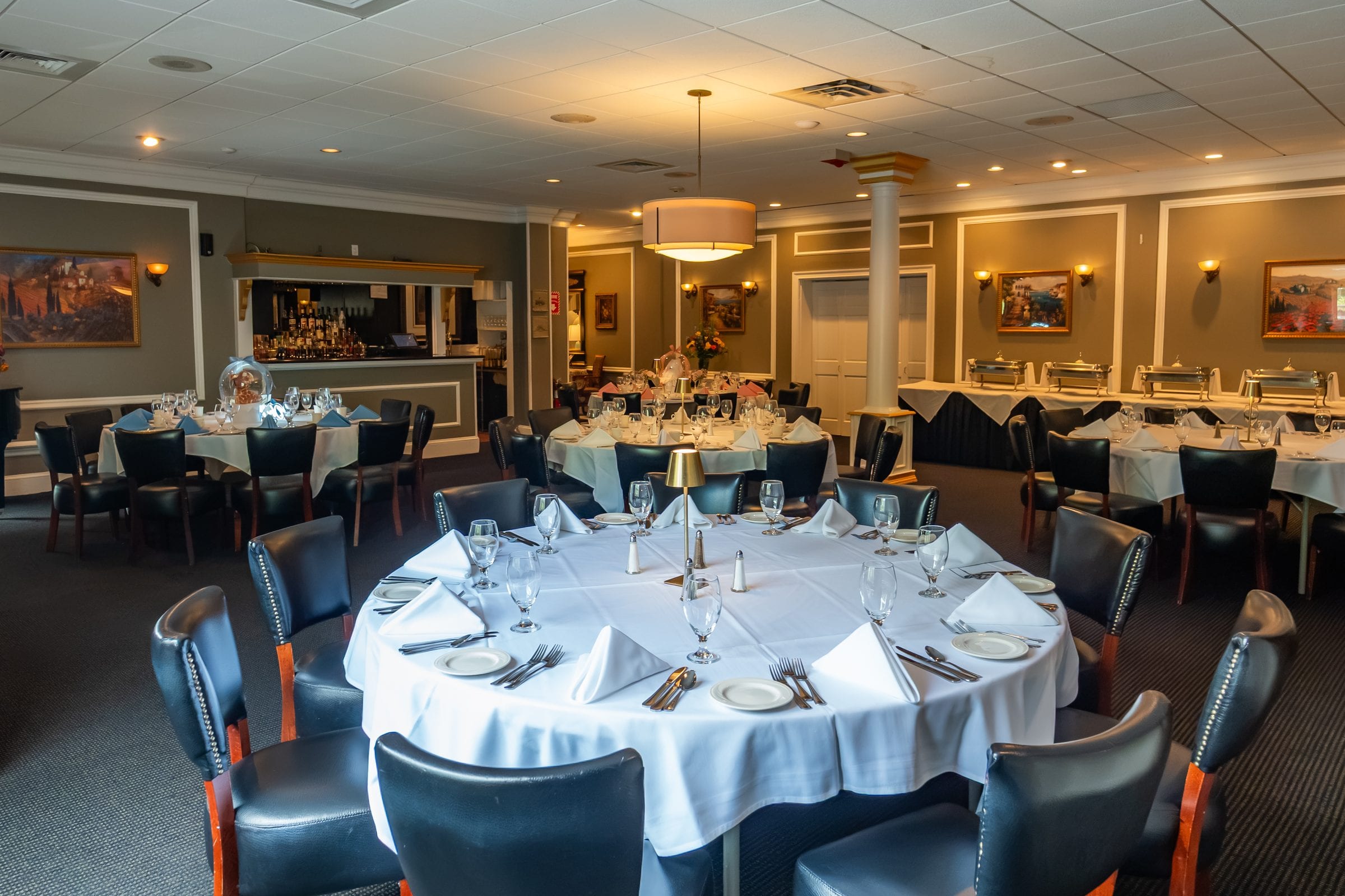A private room laid with round tables and a buffet